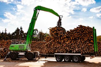 Holzumschlag im Sägewerk und auf dem Rundholzplatz: SENNEBOGEN 830 Mobil Trailer mit Anhänger Umschlagbagger Umschlagmaschine - Verladung von Rundholz und Baumstämmen