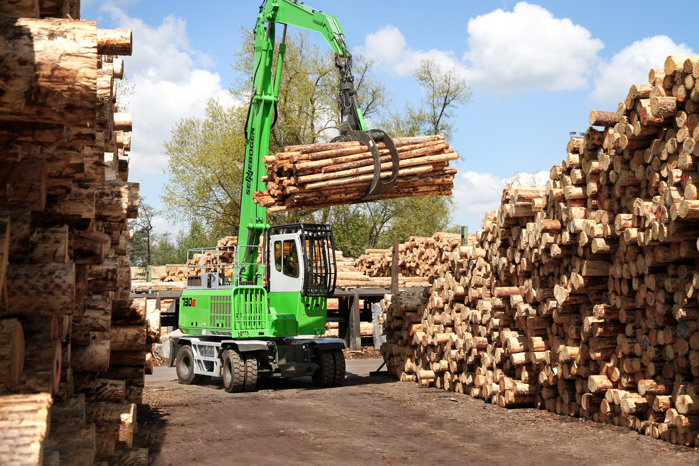 Holzumschlag im Sägewerk und auf dem Rundholzplatz: SENNEBOGEN 730 E Umschlagbagger Umschlagmaschine - Verladung von Rundholz und Baumstämmen