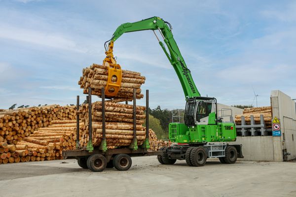 SENNEBOGEN material handler in saw mill, log transport, timber handling with timber grab SENNEBOGEN material handler in saw mill, log transport, timber handling with timber grab