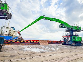 SENNEBOGEN 870 E material handler handling scrap metal with a grab during cargo ship operations at the port of Hereke.