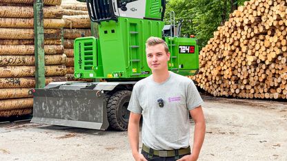 Holzhof Schmidt employees standing in front of the SENNEBOGEN 724 G in the sawmill's roundwood storage area.