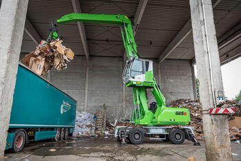 Umschlagbagger Umschlagmaschine SENNEBOGEN 825 in der Abfalllogistik, Wertstoffaufbereitung und im Recycling LKW beladen Beladung LKW mit hochfahrbarer Kabine und Mehrschalengreifer