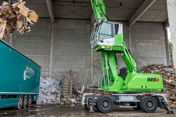 Umschlagbagger Umschlagmaschine SENNEBOGEN 825 in der Abfalllogistik, Wertstoffaufbereitung und im Recycling LKW beladen Beladung LKW mit hochfahrbarer Kabine und Mehrschalengreifer