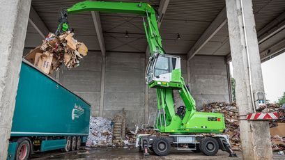 Umschlagbagger Umschlagmaschine SENNEBOGEN 825 in der Abfalllogistik, Wertstoffaufbereitung und im Recycling LKW beladen Beladung LKW mit hochfahrbarer Kabine und Mehrschalengreifer