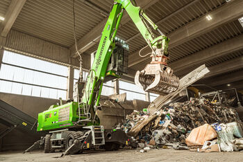 ELECTRIC MATERIAL HANDLER SENNEBOGEN 821 WITH CEILING POWER SUPPLY A IN WASTE SORTING FACILITY, processing of recyclable materials