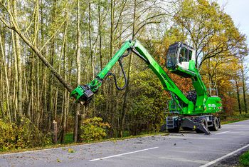 SENNEBOGEN 718 E tree handling machine lifting a felled tree trunk during professional tree care operations.