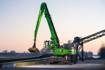 SENNEBOGEN 850 G Hybrid beim Be- und Entladen eines Frachtschiffs im Hafen in Nordfrankreich während der Dämmerung.