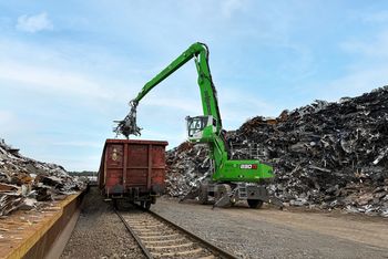 SENNEBOGEN 830 G material handler loading scrap metal into a freight railcar at the recycling yard in Salzgitter.