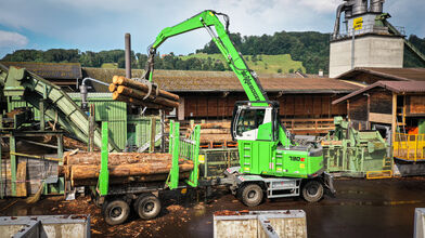 SENNEBOGEN 730 Holzumschlagmaschine im Pick & Carry-Einsatz mit Anhänger, Sägewerk, Schweiz