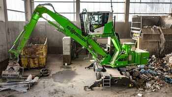 ELECTRIC MATERIAL HANDLER SENNEBOGEN 821 WITH CEILING POWER SUPPLY A IN WASTE SORTING FACILITY, processing of recyclable materials