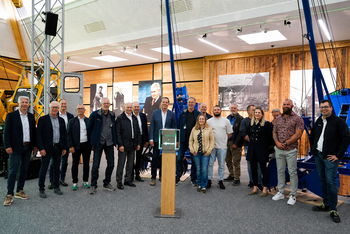 Vertreter von Dutch Offshore, Van den Heuvel und SENNEBOGEN vor dem Übergabegeschenk zur Partnerschaft beim SENNEBOGEN 6220 HD.