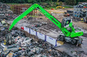 Material handler SENNEBOGEN 830 E scrap handling on scrap yard with orange peel grab