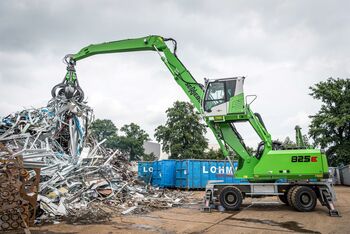 Loading scrap, scrap handling with material handler scrap loader SENNEBOGEN 825 E with orange peel grab on the scrap yard