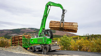 Die SENNEBOGEN 735 E Pick and Carry Maschine mit elektrischem Green Efficiency Drive Antrieb beim Holzumschlag mit Anhänger.