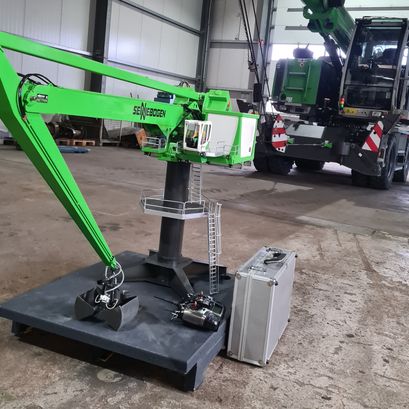 Fertiges, grün foliertes Modell des SENNEBOGEN 8160 EQ Balancer mit hydraulischem Ausleger und Greifer.