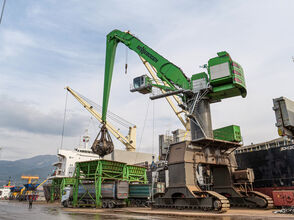 SENNEBOGEN largest material handler in the world 895 E port handling cargo orange peel grab