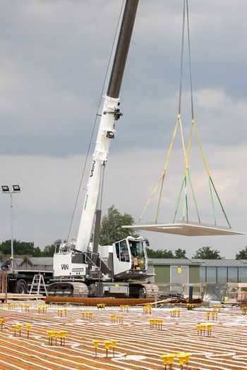 SENNEBOGEN 653 Electro Battery crane positioning a precast concrete element during the construction of an electric bus depot in Breda.