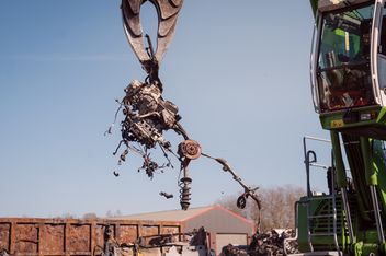 Powerhand-System des SENNEBOGEN 821 E beim präzisen Trennen ausgebauter Fahrzeugkomponenten in der Altfahrzeugverwertung.