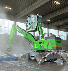 Battery-powered material handler SENNEBOGEN 817 E Electro Battery sorting recycling material in a hall.