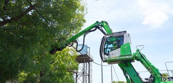 SENNEBOGEN 718 E safely pruning a tree in close proximity to overhead power lines.