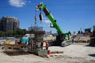 SENNEBOGEN 6113 E Crawler telecrane during lifting work on a Paris construction site