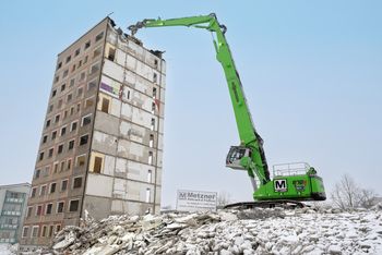 SENNEBOGEN 870 E demolition excavator dismantling a high-rise building during an urban demolition project.