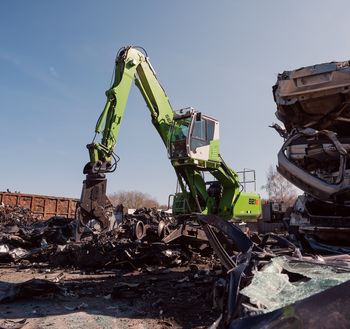SENNEBOGEN 821 E mit Powerhand-System bei der Demontage gestapelter Altfahrzeuge auf dem Betriebsgelände von Recycar.