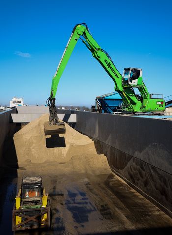 SENNEBOGEN 830 G Hybrid entlädt Sand aus dem Laderaum eines Binnenschiffs im Hafen von Amsterdam.