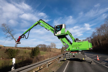 Embankment maintenance on busy road with tree felling machine material handler SENNEBOGEN 728 E