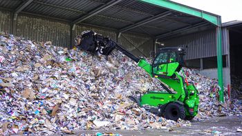SENNEBOGEN 360 G telehandler handling recyclable materials at a recycling facility.