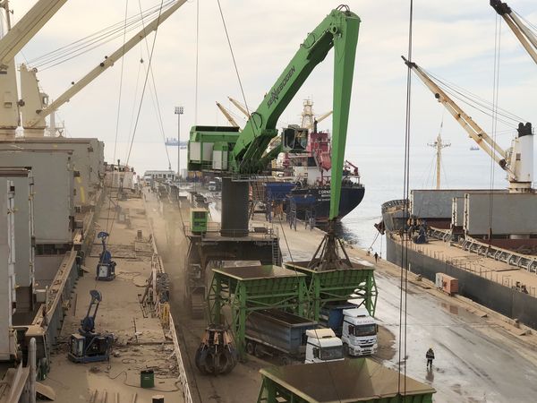 SENNEBOGEN largest material handler in the world 895 E port handling cargo orange peel grab