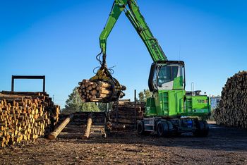 SENNEBOGEN 730 E pick-and-carry machine transporting multiple logs at a sawmill.