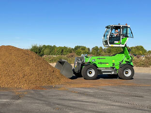 Sennebogen 355 E telehandler is loading with a bucket light bulk material during grape harvest.