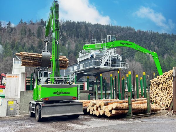 SENNEBOGEN 840 E auf Schienenportal bei der Entleerung von Rundholzboxen im Sägewerk.
