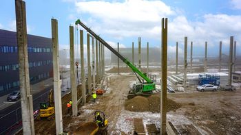 SENNEBOGEN 683 E Raupen-Teleskopkran bei präzisen Montage- und Pick-and-Carry-Arbeiten auf einer Baustelle.