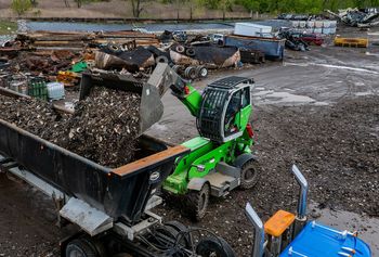 SENNEBOGEN 360G mit Schaufel im Recyclingbetrieb beim Aufnehmen und Verladen von Schrottmaterial. 